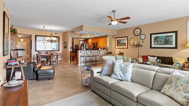 living room featuring light tile patterned floors and ceiling fan with notable chandelier