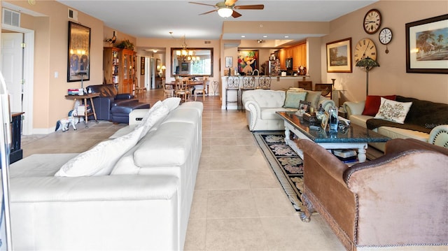 tiled living room featuring ceiling fan with notable chandelier