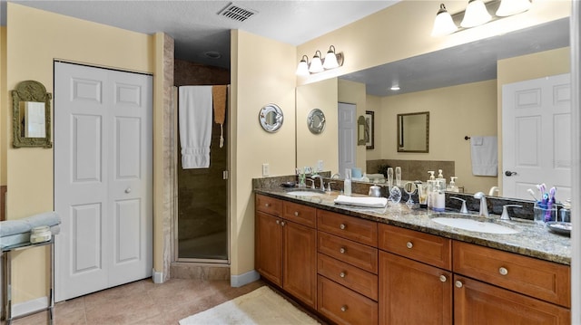 bathroom with tile patterned floors, vanity, and walk in shower