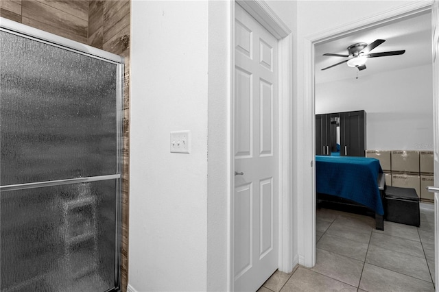 bathroom with tile patterned floors, ceiling fan, and a shower with shower door