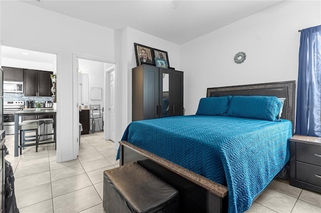 bedroom with light tile patterned floors and ensuite bath