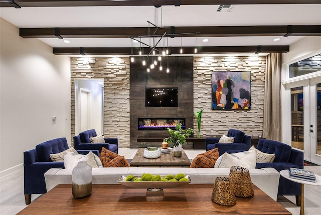 living room featuring beamed ceiling, a tiled fireplace, and light hardwood / wood-style floors