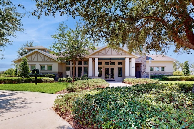 view of front facade with a front yard and french doors