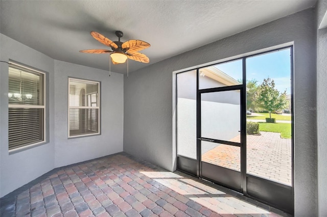 unfurnished sunroom with ceiling fan and a wealth of natural light