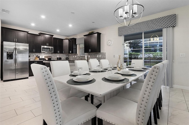 dining area featuring a chandelier and light tile floors