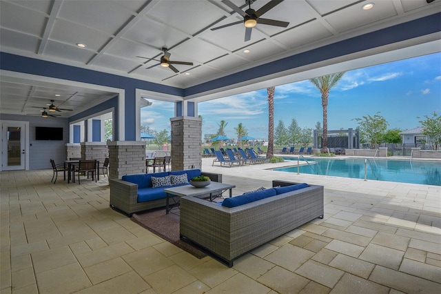 view of pool with an outdoor living space, ceiling fan, and a patio area