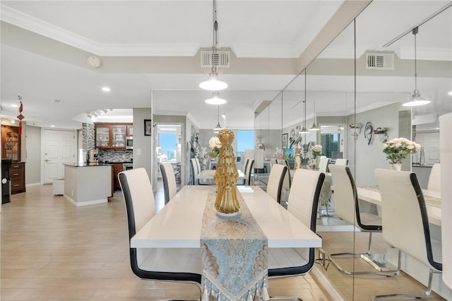 dining area featuring ornamental molding and light hardwood / wood-style floors