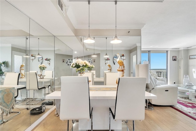 dining room featuring light hardwood / wood-style flooring and crown molding