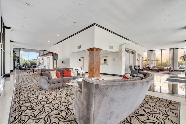 living room with decorative columns and light tile flooring