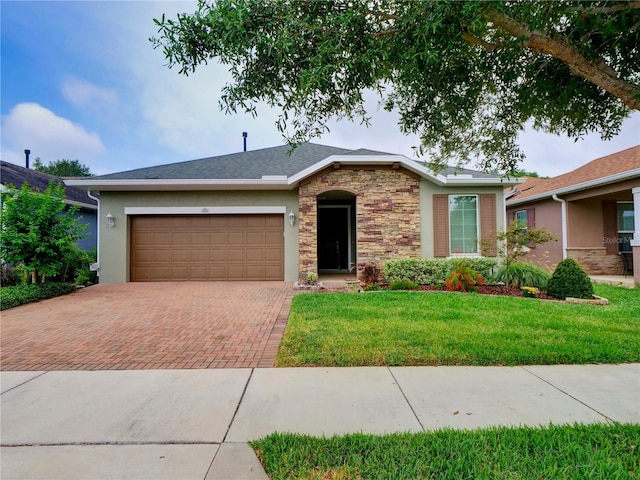 ranch-style house featuring a garage, stone siding, decorative driveway, stucco siding, and a front lawn