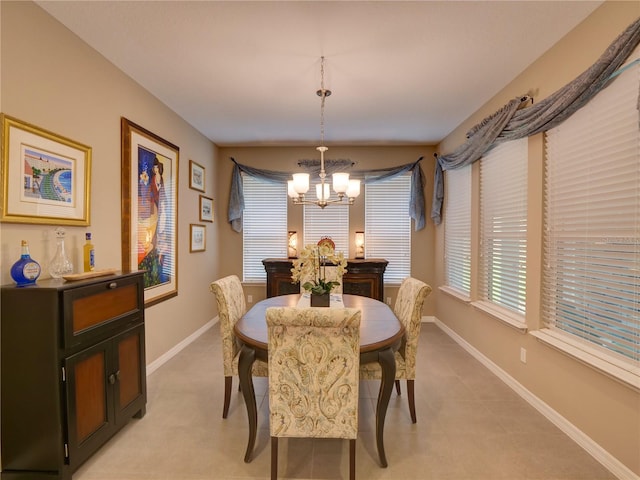 dining space featuring baseboards and a chandelier