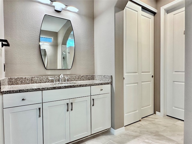 bathroom featuring a textured wall and vanity