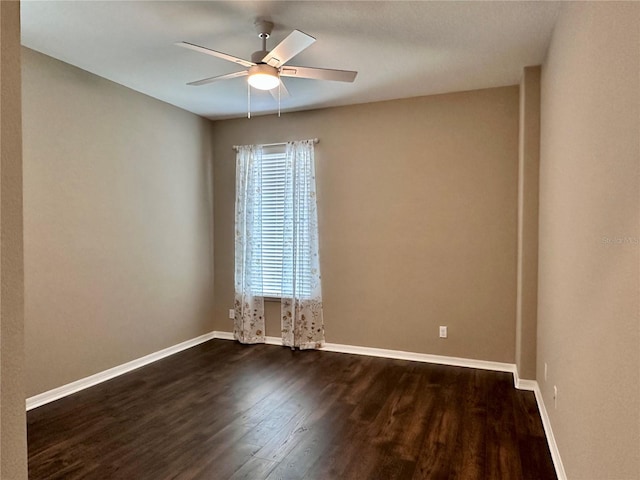 unfurnished room with dark wood-style floors, baseboards, and a ceiling fan