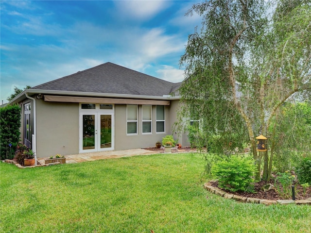 rear view of property with french doors, roof with shingles, a lawn, and stucco siding