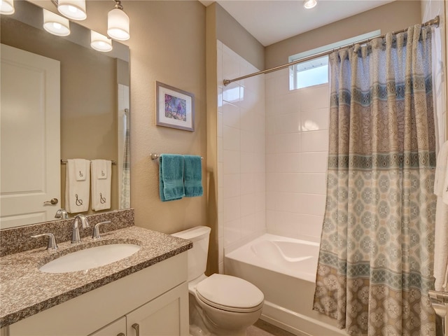 full bathroom featuring vanity, shower / bath combo with shower curtain, and toilet