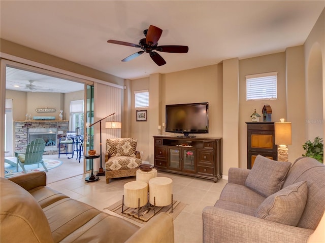 living room with light tile patterned flooring, a fireplace, and ceiling fan