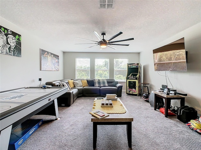 living room featuring a textured ceiling, ceiling fan, and carpet