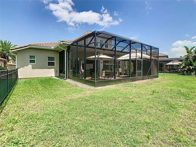 rear view of property with a lanai and a lawn