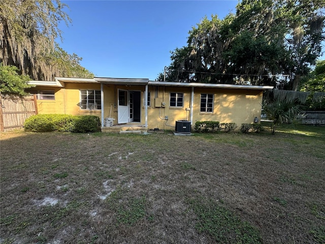 ranch-style house with a front yard and central AC