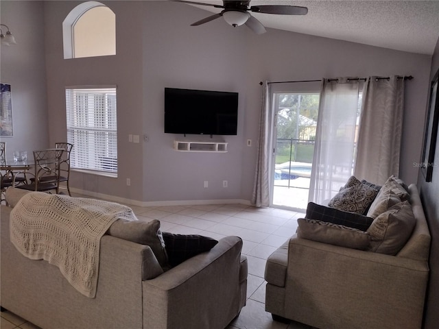 tiled living room featuring ceiling fan, lofted ceiling, and a textured ceiling