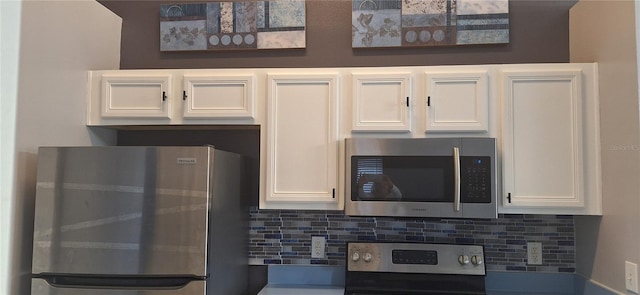 kitchen featuring stainless steel appliances, white cabinetry, and decorative backsplash