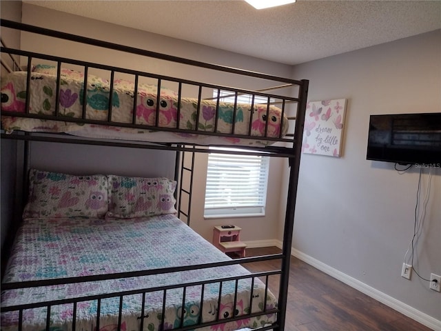 bedroom with hardwood / wood-style flooring and a textured ceiling