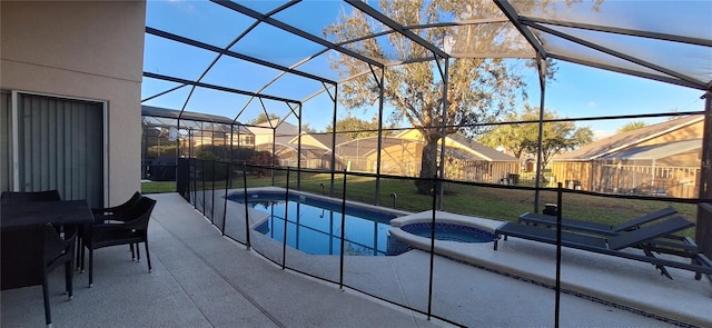 view of swimming pool featuring an in ground hot tub, a yard, glass enclosure, and a patio area