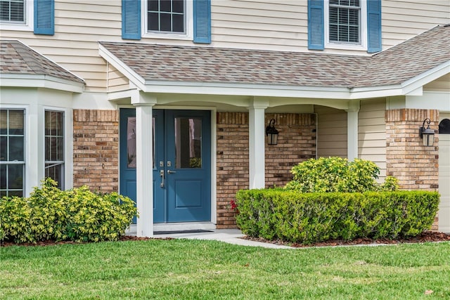 view of exterior entry with a porch and a lawn