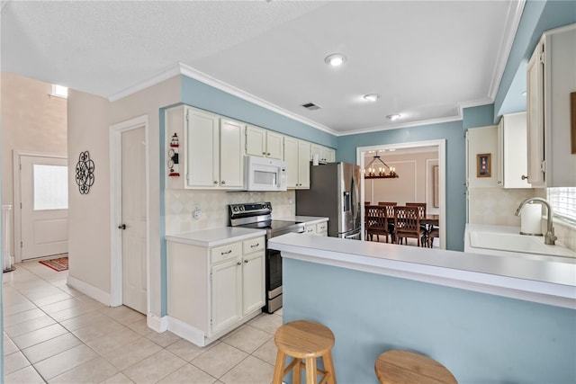 kitchen with appliances with stainless steel finishes, tasteful backsplash, sink, and white cabinetry