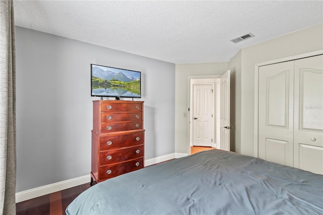 bedroom featuring hardwood / wood-style flooring, a closet, and a textured ceiling