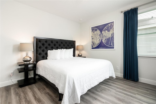 bedroom featuring baseboards and wood finished floors