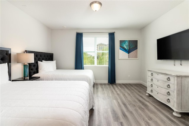 bedroom featuring light wood-style floors and baseboards