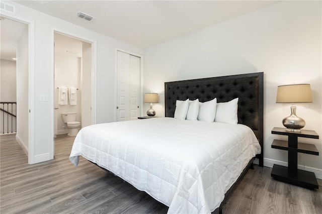 bedroom featuring a closet, visible vents, baseboards, and wood finished floors