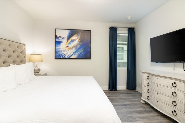 bedroom featuring dark wood finished floors and baseboards