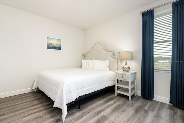 bedroom with baseboards and wood finished floors