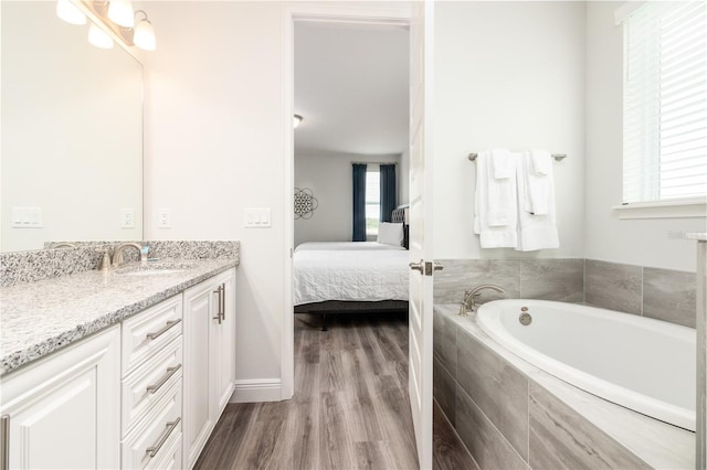 full bathroom with vanity, wood finished floors, a wealth of natural light, and ensuite bathroom