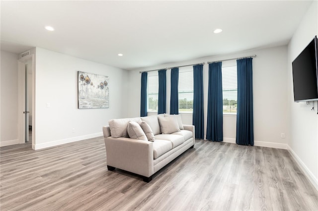 living room featuring recessed lighting, light wood-type flooring, visible vents, and baseboards