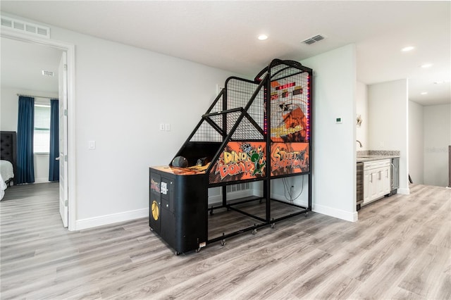 office area featuring wine cooler, light wood-type flooring, visible vents, and baseboards