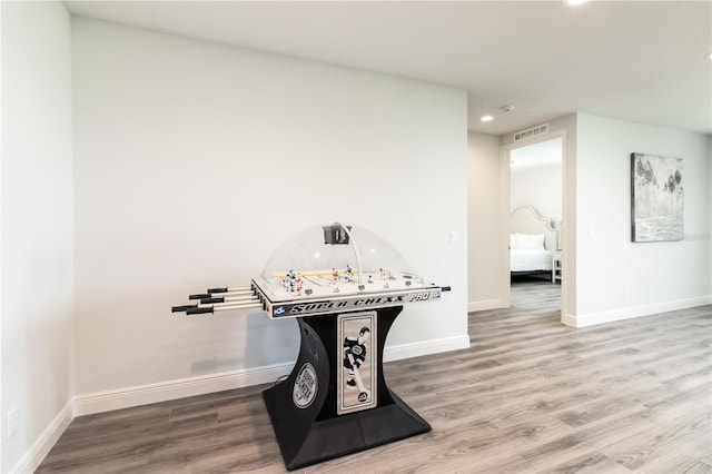 recreation room with visible vents, baseboards, and wood finished floors