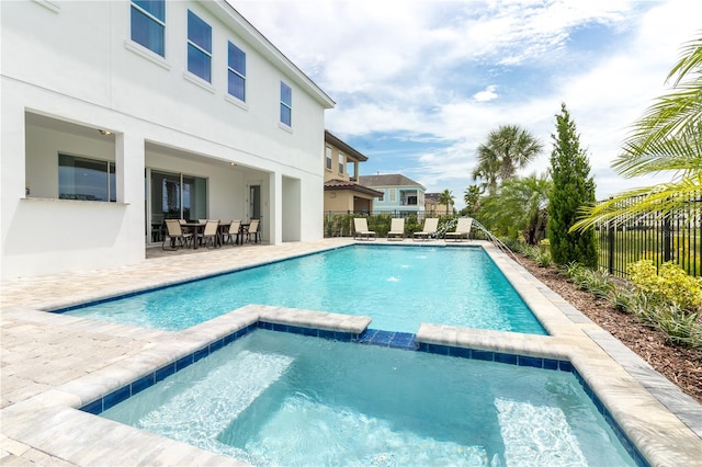 view of pool with a patio area and an in ground hot tub