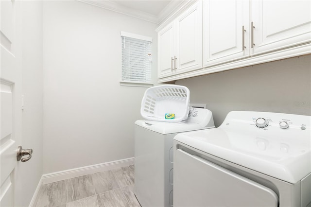 laundry area featuring cabinets, ornamental molding, and washer and clothes dryer