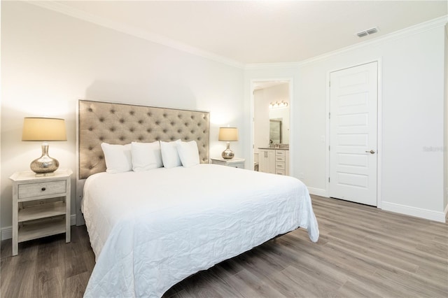 bedroom with ornamental molding, connected bathroom, and dark wood-type flooring