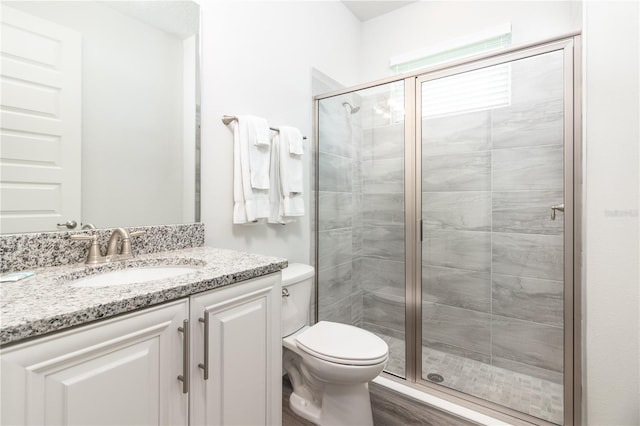 bathroom with a shower with door, hardwood / wood-style floors, toilet, and large vanity