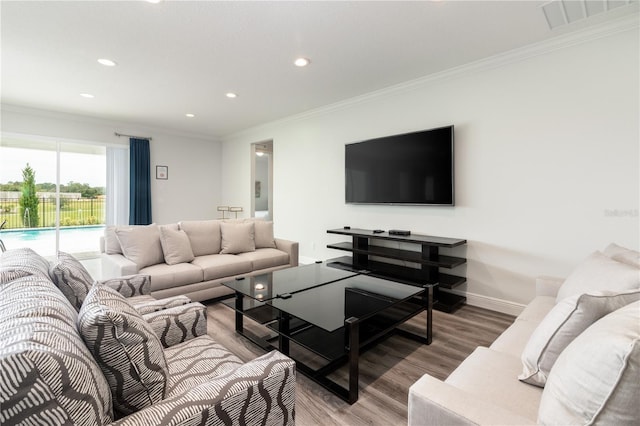 living room with baseboards, visible vents, wood finished floors, crown molding, and recessed lighting