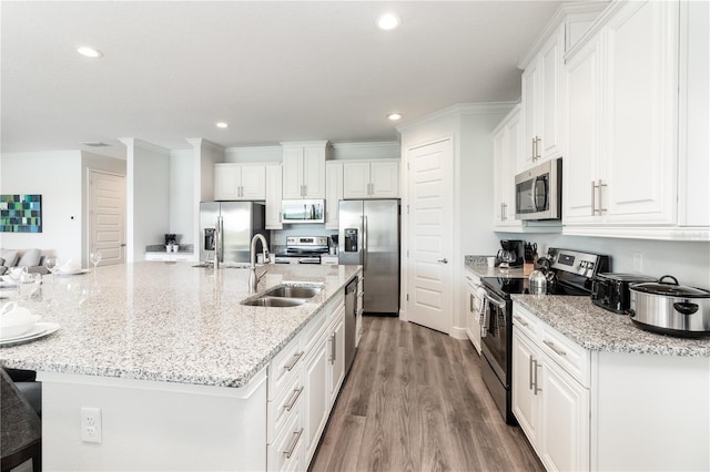 kitchen featuring an island with sink, a breakfast bar, appliances with stainless steel finishes, and white cabinets