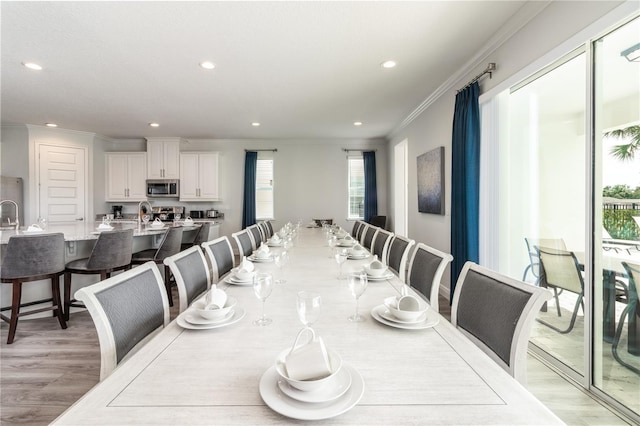 dining room featuring light wood-style floors, ornamental molding, and recessed lighting