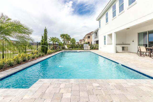 view of swimming pool with a fenced backyard, a fenced in pool, a patio, and area for grilling