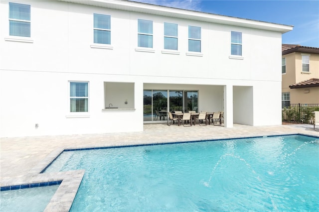 rear view of house featuring a patio and a fenced in pool