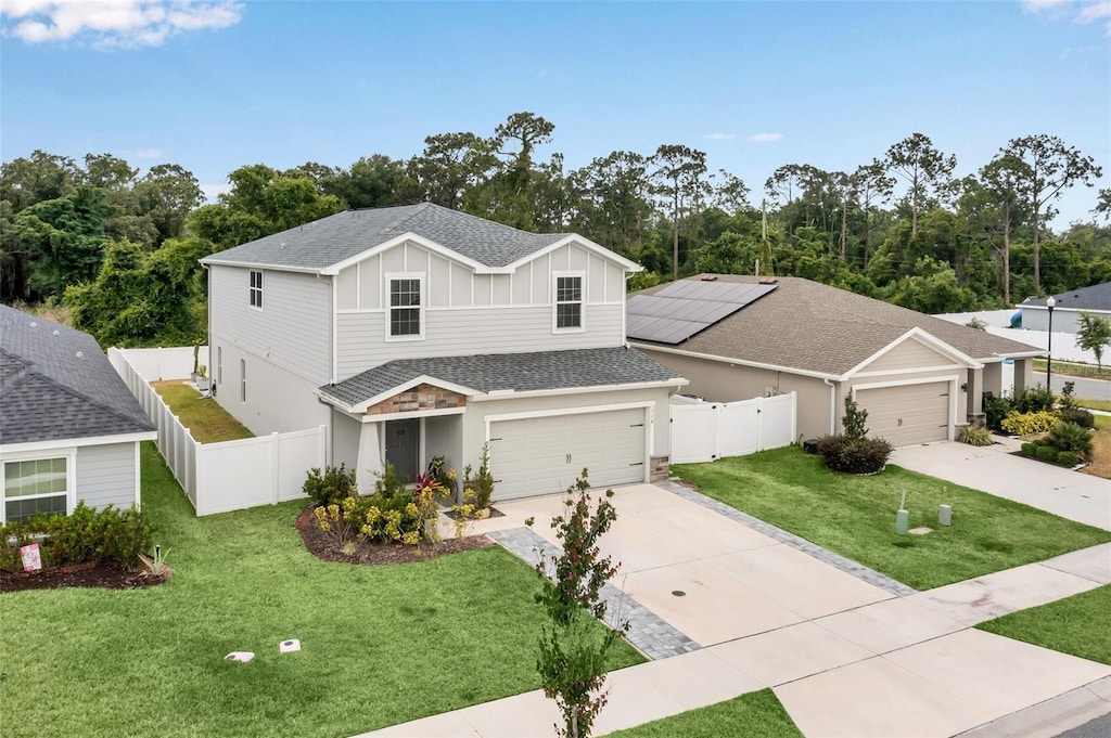 view of front of home featuring a garage, a front lawn, and solar panels