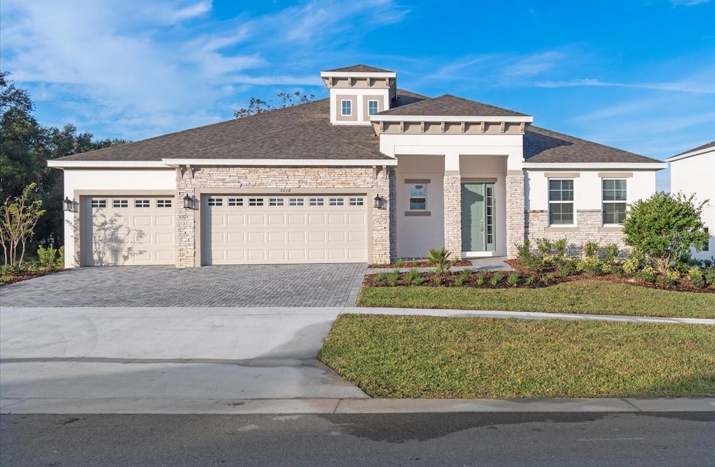 view of front of property featuring a garage and a front lawn